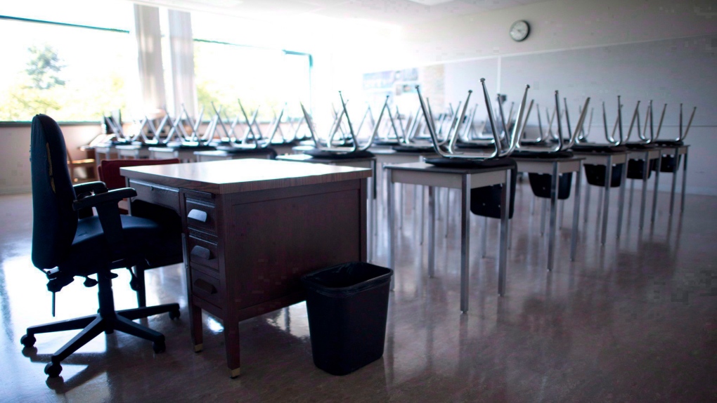 FILE - AN empty teacher's desk is pictured at the front of a empty classroom at Mcgee Secondary school in Vancouver on Sept. 5, 2014. (Jonathan Hayward/The Canadian Press)