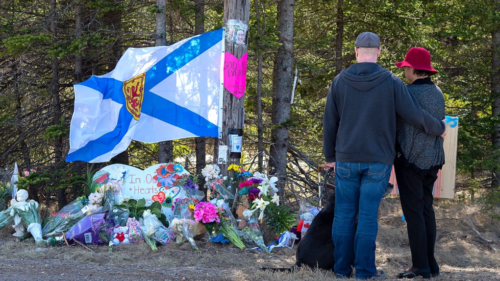 A couple pays their respects at a roadblock in Portapique, N.S. on Wednesday, April 22, 2021. RCMP say at least 22 people are dead after a man, who at one point wore a police uniform and drove a mock-up cruiser, went on a murder rampage in Portapique and several other Nova Scotia communities. THE CANADIAN PRESS/Andrew Vaughan