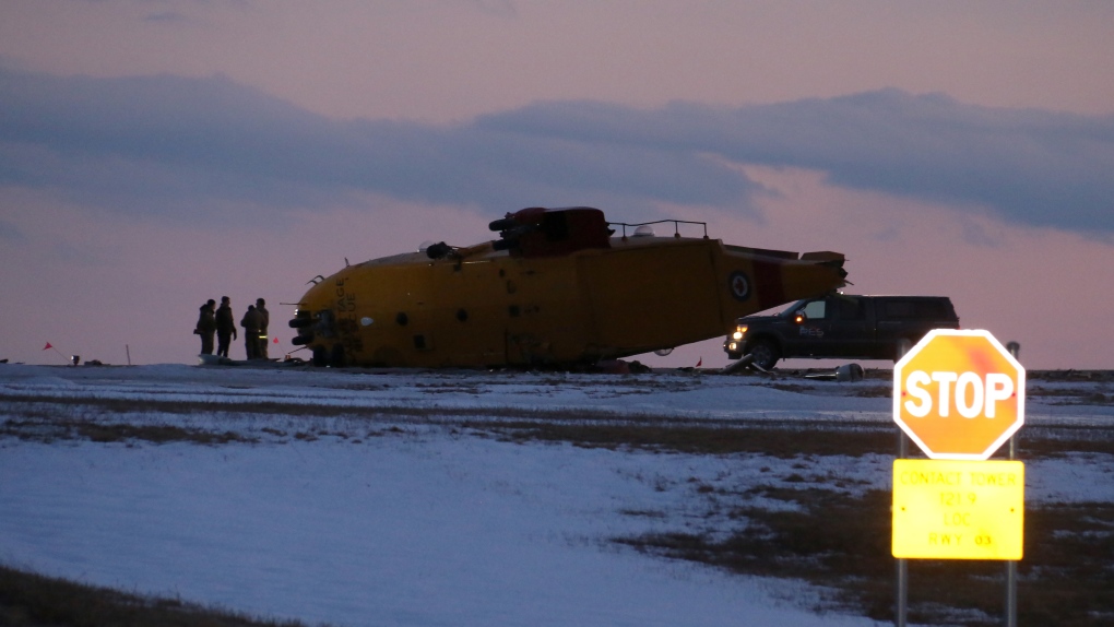 Emergency crews work around the wreckage of a downed CH-149 Cormorant search and rescue helicopter at 9 Wing Canadian Forces Base Gander, in Gander, N.L., Thursday, March 10, 2022. THE CANADIAN PRESS/Scott Cook 