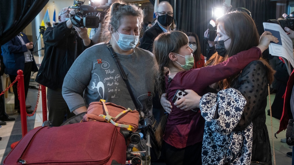 Nine-year-old Zoriana, middle, greets her sister, Sofiia, as her and their mother, Natalia, arrive from Ukraine in St. John's, Monday, May 9, 2022. THE CANADIAN PRESS/Greg Locke 