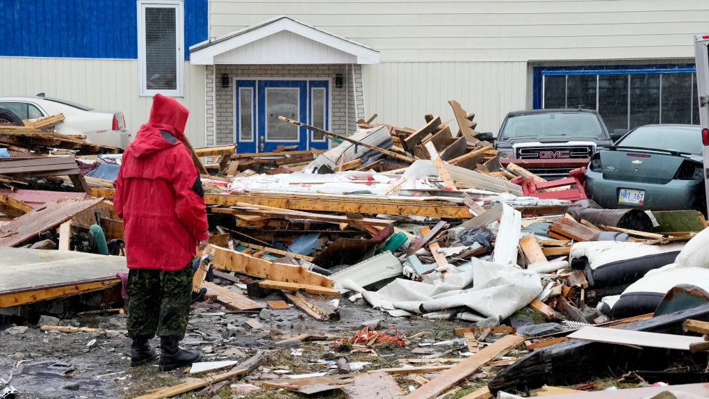 A Canadian Forces Ranger examines damage to a home in Port aux Basques, N.L., Monday, Sept. 26, 2022. THE CANADIAN PRESS/Frank Gunn