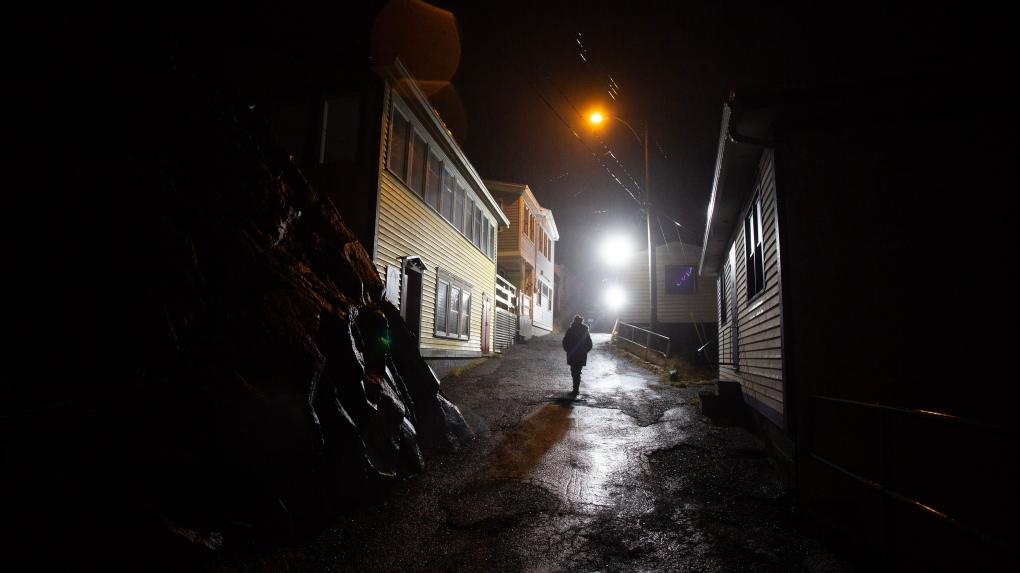 A woman walks in her neighbourhood of the Battery historical area of St. John's N.L. on Monday, January 16, 2023. (THE CANADIAN PRESS/Paul Daly)
