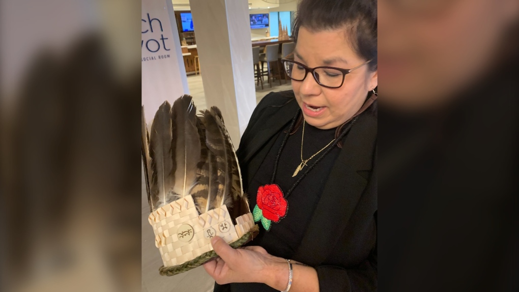 Andrea Paul, the regional chief of the Assembly of First Nations in Nova Scotia, explains the Mi’kmaq hieroglyphics on the headdress made for her induction into her new position in Dartmouth, N.S. on Thursday Nov. 30, 2023. Paul is the first woman to hold the position in Nova Scotia. (Source: THE CANADIAN PRESS/Michael Tutton)